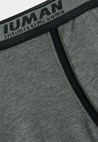 Grijze katoen boxershort met een zwarte elastische tailleband met opvallende witte letters. Soepele textuur, nauwsluitend ontwerp en zijnaad.