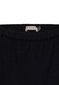 Fascia in tessuto intrecciato nero con superficie testurizzata. L'etichetta reca la scritta "Retour Jeans" in rosso con un'etichetta in tessuto aggiuntiva sottostante.