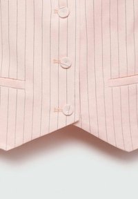Jasnoróżowa kamizelka w pionowe prążki, z czterema guzikami, dwiema bocznymi kieszeniami i spiczastym dołem. Gładka, dopasowana faktura materiału.