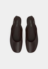 Tmavě hnědé nazouvací boty s hladkým matným povrchem a zaoblenou špičkou. Vybaveny postranní sponou pro nastavení velikosti. Logo značky na stélce.