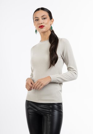 Pulover tricotat de culoare gri deschis, cu mâneci lungi și gât rotund, asortat cu pantaloni din piele negri. Țesătura pare moale și aderentă.