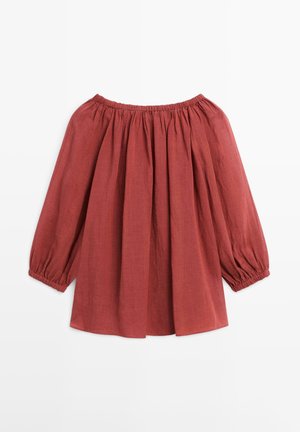 Bluse in Rostfarbe mit schulterfreiem Schnitt, langen Puffärmeln und elastischen Raffungen am Ausschnitt und an den Manschetten, flach auf weißem Hintergrund dargestellt.