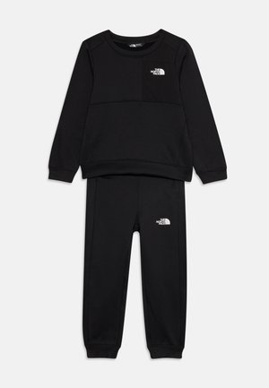 Sweatshirt noir et ensemble de pantalons de survêtement assortis en tissu doux. Présente un logo sur la poche de la poitrine et sur les hanches, avec des poignets et une taille côtelés.