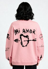 Felpa rosa over-size con grafica nera: "Mi Amor", cuori, teschi e frecce. Tessuto morbido con polsini e orlo a coste.