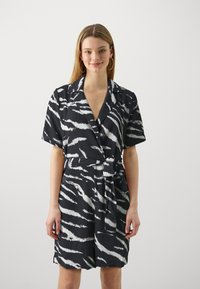 Robe noire et blanche à rayures à manches courtes avec un design enveloppant et une ceinture à nouer, dotée d'un décolleté en V et d'un tissu texturé léger.