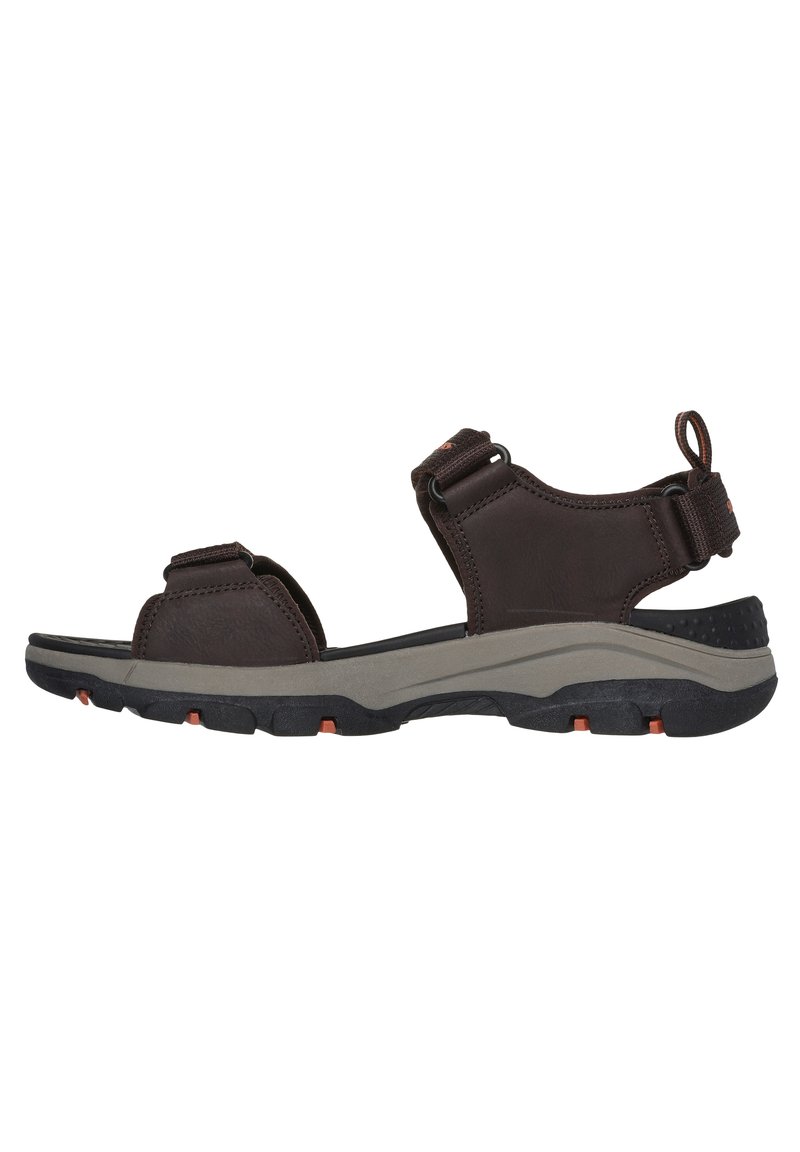 Sandal de color marrón con correas ajustables, plantilla acolchada y suela de goma negra texturizada con acentos naranjas y forma contorneada.