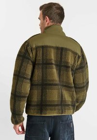 Groene en zwarte geruite fleecedesign met verhoogde kraag, gestructureerde stof en contrasterend stofpaneel op de schouders. Casual ontwerp voor heren.