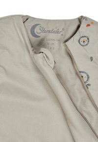 Beiger Schlafsack mit Reißverschluss, verziert mit gestickten Löwen- und Blättermotiven. Das Material wirkt weich und glatt, geeignet für Kinder im Alter von 0-8 Monaten.