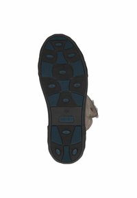 Semelle en caoutchouc noir avec une texture antidérapante, ornée d'accents bleus et d'un motif ovale. Matériau supérieur beige avec un bord en fausse fourrure.