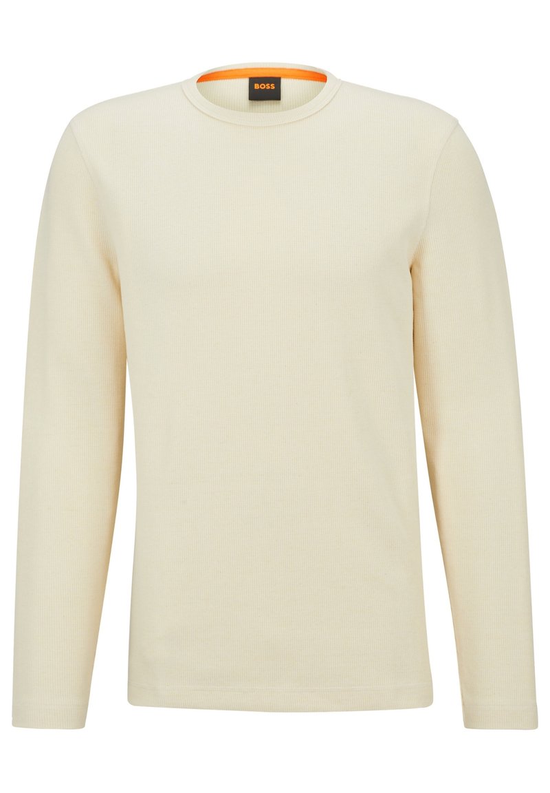 Långärmad beige ribbad t-shirt med rundhals och kontrasterande orange kant inuti kragen. Tillverkad av mjukt, texturerat tyg.