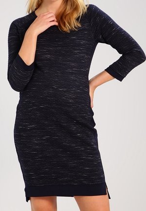 Robe extensible bleu marine avec des manches trois-quarts, un col rond et des fentes sur les côtés. Tissu texturé avec un motif mélangé subtil.