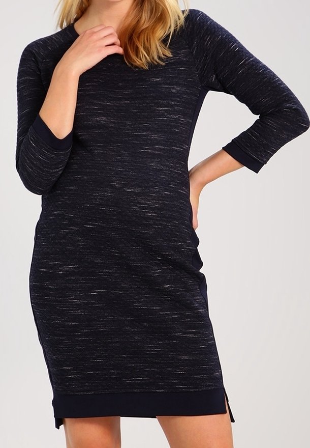 Tummansininen, venytettävä mekko, jossa on kolme neljännes hihaa, pyöreä kaula-aukko ja sivuhalkiot. Rakenteellinen kangas, jossa on hillitty heather-kuvio.