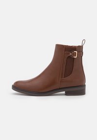 Brown leather ankle boot with a low block heel, elastic side panels, and a decorative buckle detail on the side. Smooth texture.