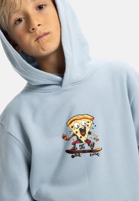Felpa con cappuccio di colore azzurro chiaro che presenta un personaggio di pizza cartoonesco su uno skateboard, con colori vivaci, espressione facciale dettagliata e design giocoso.