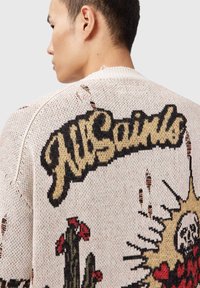 Πλεκτό πουλόβερ σε κρεμ χρώμα με μαύρο και κίτρινο λογότυπο "AllSaints". Διαθέτει μεγάλα γραφικά με κάκτους, ήλιο και φθαρμένες λεπτομέρειες.