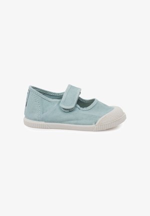 Zapato infantil de tela azul claro con puntera de goma blanca, suela blanca y una única tira de Velcro en la parte superior.