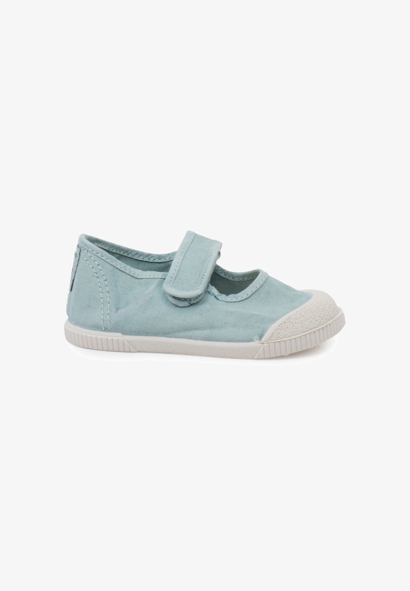 Chaussure pour enfant en tissu bleu clair avec une coque d'orteil en caoutchouc blanche, une semelle blanche et une seule bride Velcro sur le dessus.