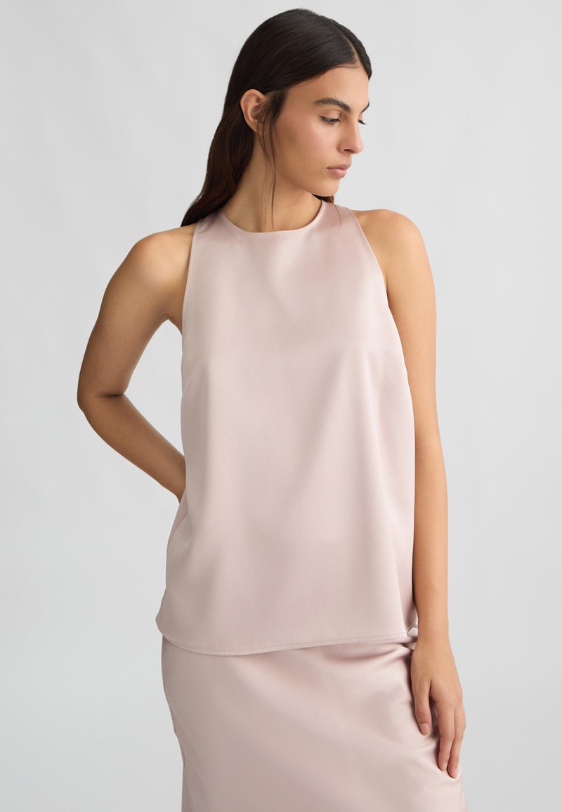 Top senza maniche di colore rosa in un tessuto morbido e leggero, con una vestibilità comoda, caratterizzato da un colletto tondo e una superficie liscia.
