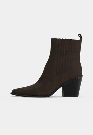 Bottine en cuir marron foncé avec bout pointu, panneau latéral élastique, languette de tirage et gros talon bloc noir.