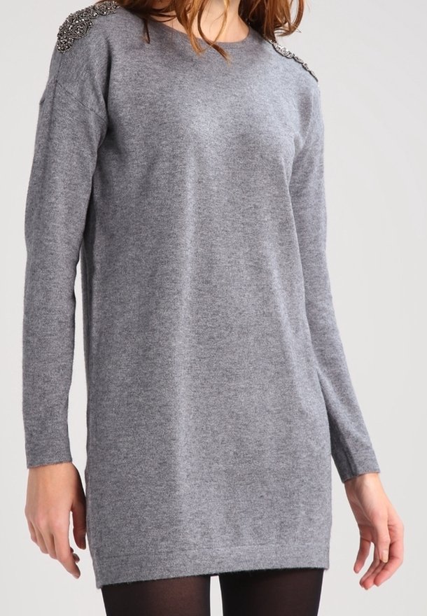 Vestito a maglia grigio con maniche lunghe, scollo rotondo, dettaglio decorativo sulle spalle, texture morbida e vestibilità rilassata che arriva fino a metà coscia.