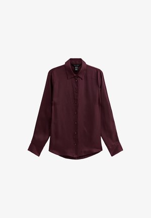 Chemise boutonnée bordeaux à manches longues, en tissu lisse et brillant, avec un col classique et un ourlet droit. Six boutons sur le devant.