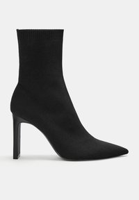 Stivale alla caviglia in stile calzino nero con punta affusolata, alto tacco a stiletto e materiale a maglia testurizzato per un design elegante.