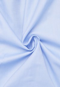 Hellblauer, strukturierter Stoff mit einem feinen Webmuster, in spiraliger Form zerknittert, der seine Weichheit und glatte Oberfläche zur Schau stellt.