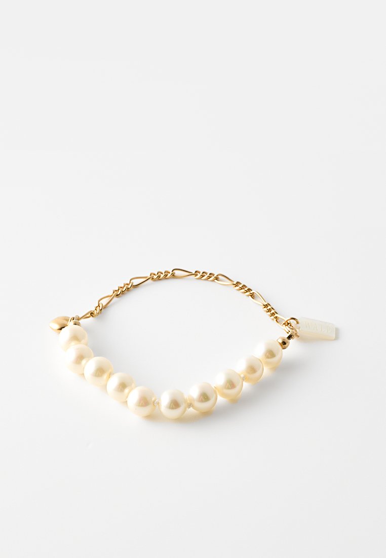 Gouden kettingarmband met afwisselend grote en kleine witte parels, met een tagdetail. Soepele, ronde textuur, minimalistisch ontwerp.