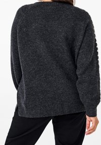 Dunkelgrauer gestrickter Pullover mit gerippten Bündchen und Saum. Verfügt über eine strukturierte Oberfläche und einen Design mit fallenden Schultern. Keine ausgeprägten Muster oder Akzente.