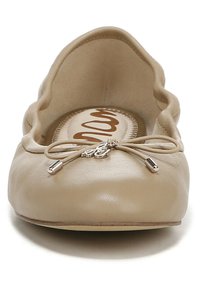 Ballerine beige realizzata in pelle liscia con bordo ondulato, dotata di un nastro a fiocco come accentuazione e dettaglio in metallo sul fiocco.