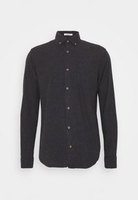 Svart långärmad skjorta av texturerad tyg, med knäppbar krage, framficka och mässingsknappar, prydd med subtila flerfärgade fläckar.