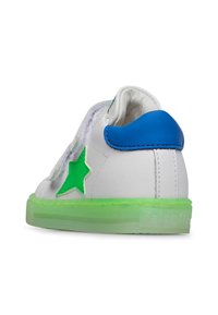 Sneaker bianca con tacco blu, accento di stella verde e suola traslucida verde. Presenta un design con lacci e una parte superiore texturizzata.