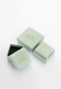 Trzy jasnozielone pudełka na biżuterię z złotym napisem „elli premium”, jedno otwarte pokazujące czarne wnętrze, prezentowane na białym tle.