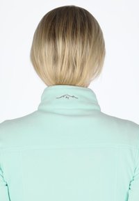 Mint green fleece jacket with a high collar, featuring subtle mountain embroidery at the back, smooth texture, and fitted design.