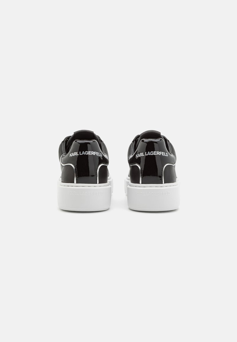 Czarne błyszczące sneakersy z białymi grubymi podeszwami, widok od tyłu, z logo "KARL LAGERFELD" na pięcie i podeszwie.