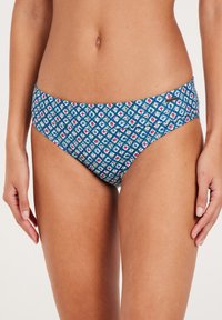 Vysoce kvalitní bikini spodní díl s hladkým materiálem. Má modrou barvu se geometrickými tvary v červené a bílé. Středně vysoký design.