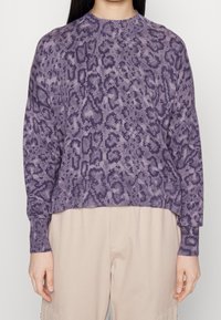 Lila gestrickter Pullover mit einem strukturierten Leopardenmuster, langen Ärmeln und einem runden Halsausschnitt, versehen mit einem gerippten Saum und Bündchen.