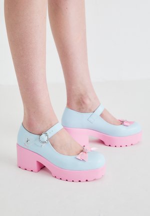 Lichtblauwe plateau schoenen met roze zool, voorzien van een gespsluiting, decoratieve strik en hartaccent. Glad afwerkingsniveau met een gestructureerde zool.