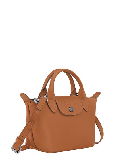Tan leather handbag with small double handles and a detachable shoulder strap. Features a flap closure with a metal snap and embossed logo.