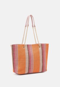 Sac fourre-tout rayé avec des motifs orange, rose et beige ; matériau tissé, poignées en cuir et accents en chaîne dorée.