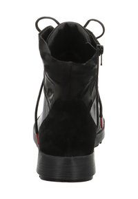 Zwarte enkellaars met een suède hak, textuur bovenkant en elastische zijpanelen. Voorzien van een ritssluiting en een lus voor makkelijk aan- en uittrekken.