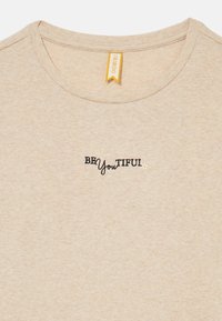 Beige Ripp-T-Shirt mit Rundhalsausschnitt und „BEYouTIFUL“-Stickerei in Schwarz mit einem Sternakzent. Brand-Tag in Gelb.