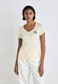 Calvin Klein Jeans MONOLOGO V NECK TEE - Triko s potiskem - vanilla