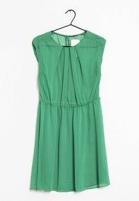 Vestido verde sin mangas con pliegues en el escote, cintura elástica y tela texturizada. Se cuelga de una percha de alambre negro contra un fondo sencillo.