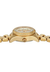 Gouden metalen polshorloge met een ronde kast, textuurbezel en schakelsband. Bevat een lichte wijzerplaat met markeringen en een logo nabij de kroon.