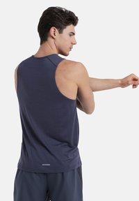 Marineblaues Tanktop mit rundem Ausschnitt, aus strukturiertem Stoff, ärmellos und mit einem reflektierenden Akzent am Saum.