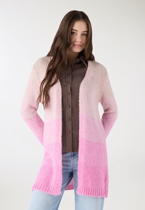 Cardigan lavorato a maglia in gradiente rosa, con maniche lunghe, apertura frontale e tessuto leggero. Indossato sopra una camicia marrone scuro con bottoni.