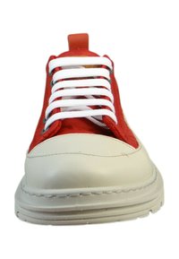 Baskets rouge et crème avec des lacets blancs, une finition texturée et un design distinctif avec une pointe ronde et une semelle rembourrée.