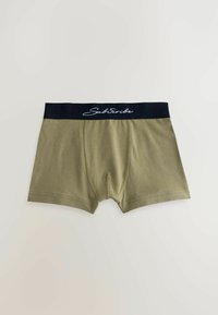 Boxer verde oliva da uomo con fascia nera e testo bianco "Subscribe", mostrati distesi su uno sfondo neutro.