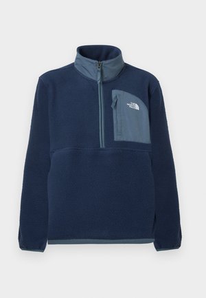 Tengerészkék polárdzseki félcipzárral, álló gallérral és cipzáras mellzsebbel, amelyen világoskék panelen a The North Face logó található.